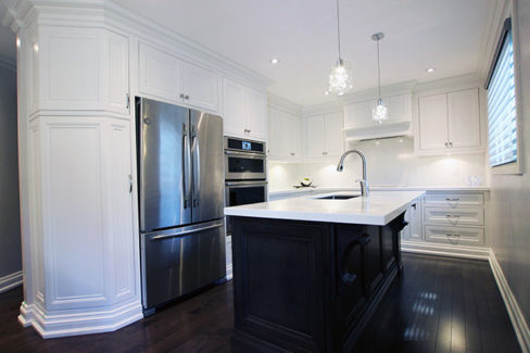 Kitchen renovation.Custom made solid wood framed kitchen. Mantel hood above the cooking area. Off white painted kitchen and dark stained island. Designed and built by JK- North York, 2017