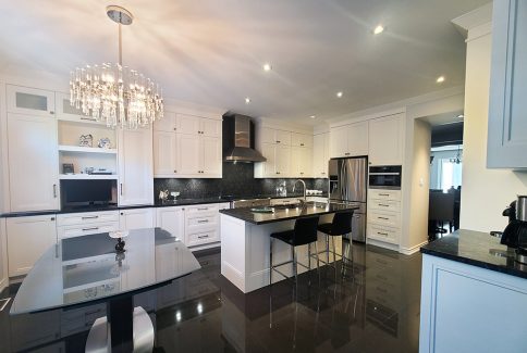 Kitchen renovation in Richmond Hill. A U shaped kitchen with island. Wall unit and pantery. Double stacked cabinets. Painted MDF. Quartz top.