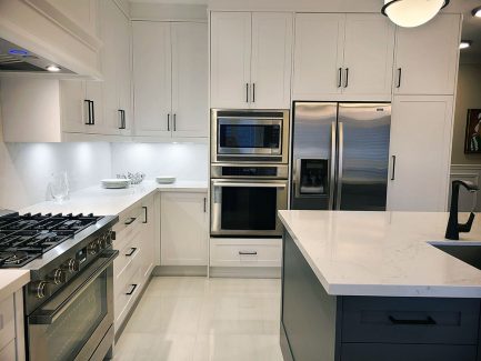 Kitchen renovation in Richmond Hill. Custom kitchen cabinets. Two tone white and gray kitchen design. Canadian quartz countertop and backsplash.