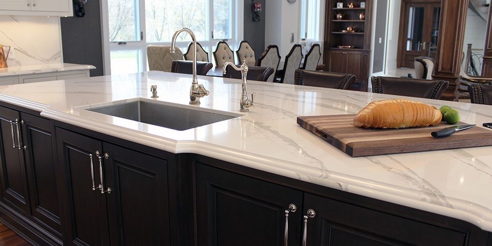 Large solid wood stained island. Sink on the island. Marble design from Cambria. Luxury edge. Toronto 2019 Large solid wood stained island. Sink on the island. Marble design from Cambria. Luxury edge. Toronto 2019
