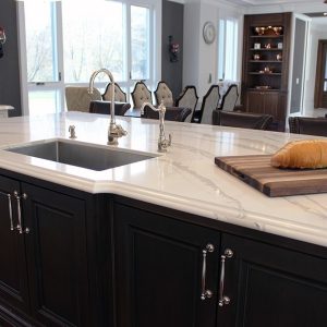 Large solid wood stained island. Sink on the island. Marble design from Cambria. Luxury edge. Toronto 2019