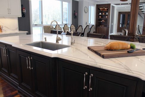 Large solid wood stained island. Sink on the island. Marble design from Cambria. Luxury edge. Toronto 2019