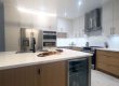 Custom made modern kitchen in Toronto Kitchen remodeling and renovation in Toronto- Two tone modern kitchen. Flat painted MDF in white and modern slim Shaker Oakwood cabinet doors. Quartz countertop and backsplash from LG Calacatta collection. Tall ceiling kitchen design. Design by JK 2023