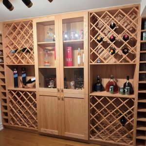Winecellar custom made winecellar solid Oakwood finished with lacqer in natural tone wine racks for wine and liquor bottoles Desingned and build by Joseph kitchen and bath Toronto