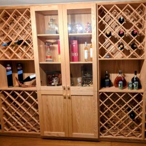 custom made winecellar solid Oakwood finished with lacqer in natural tone wine racks for wine and liquor bottoles Desingned and build by Joseph kitchen and bath Toronto
