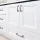 White bathroom vanity with brushed nickel hardware and black countertop.
