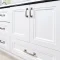 White bathroom vanity with brushed nickel hardware and black countertop.