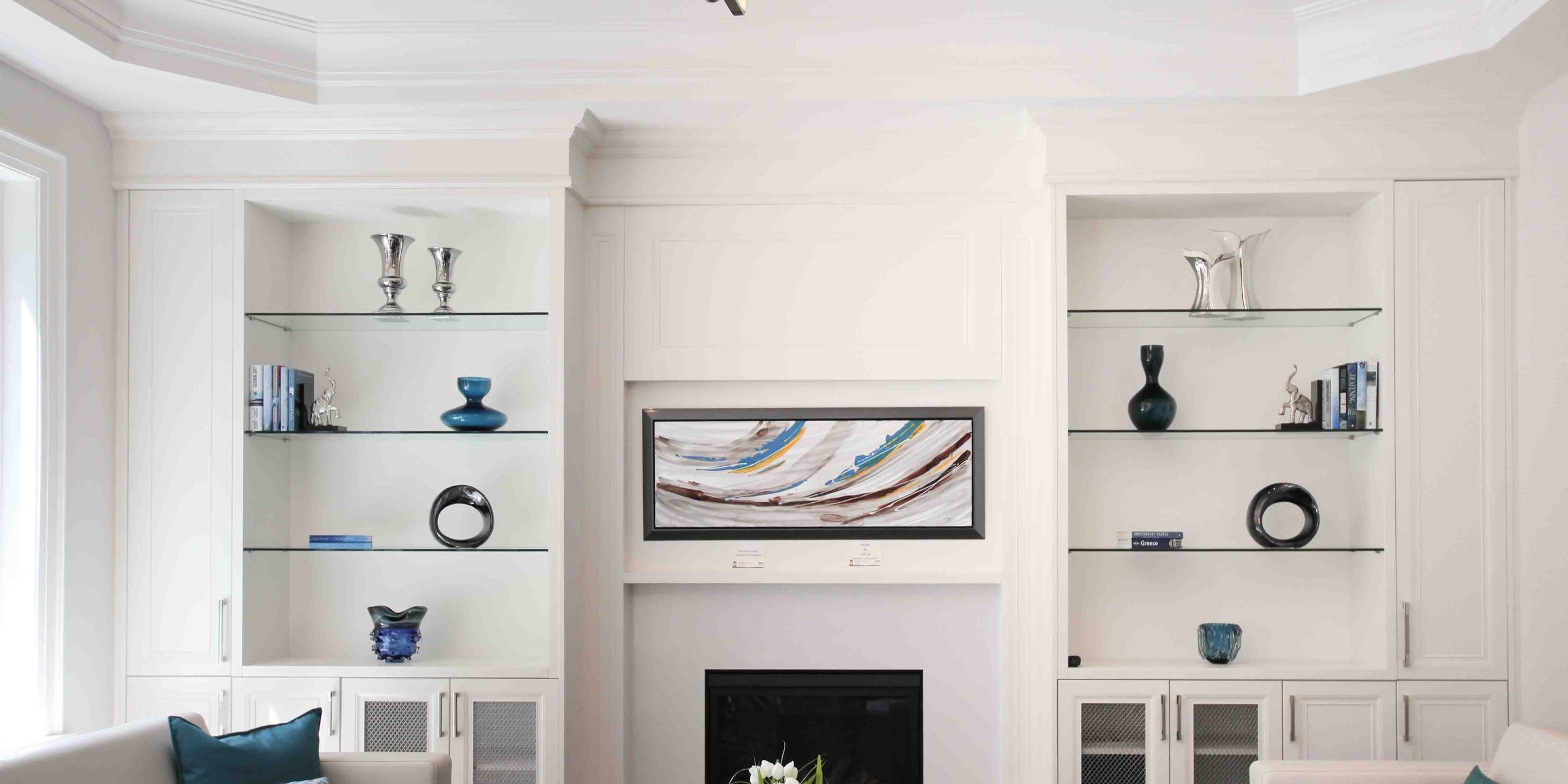 usersFfed afe da afffacdFlibraryFcac bad f bc eefadbF Modern living room with white built-in shelves, fireplace, and abstract art.