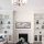 Modern living room with white built-in shelves, fireplace, and abstract art.