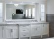 A modern white bathroom vanity with double sinks and a large mirror.