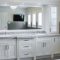 A modern white bathroom vanity with double sinks and a large mirror.