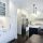 Modern white kitchen with a large stainless steel refrigerator and island.