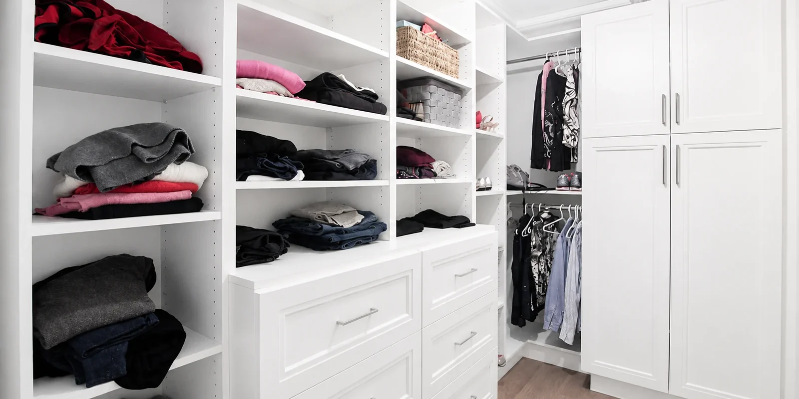 usersFfed afe da afffacdFlibraryFbd fc c bec fbdFWalk inClosetDesign A well-organized white walk-in closet with shelves, drawers, and hanging clothes.