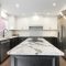 Modern kitchen with black and white cabinets and granite island.