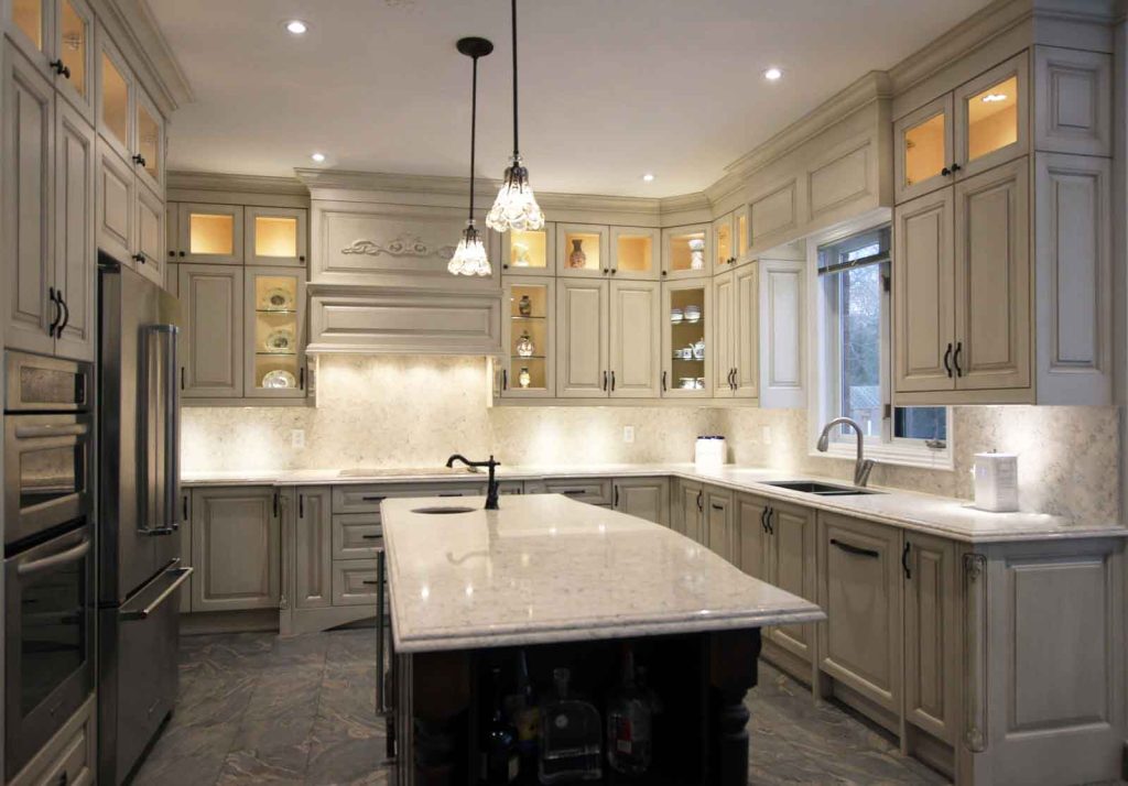 A spacious kitchen with light gray cabinets, a large island, and stainless steel appliances.