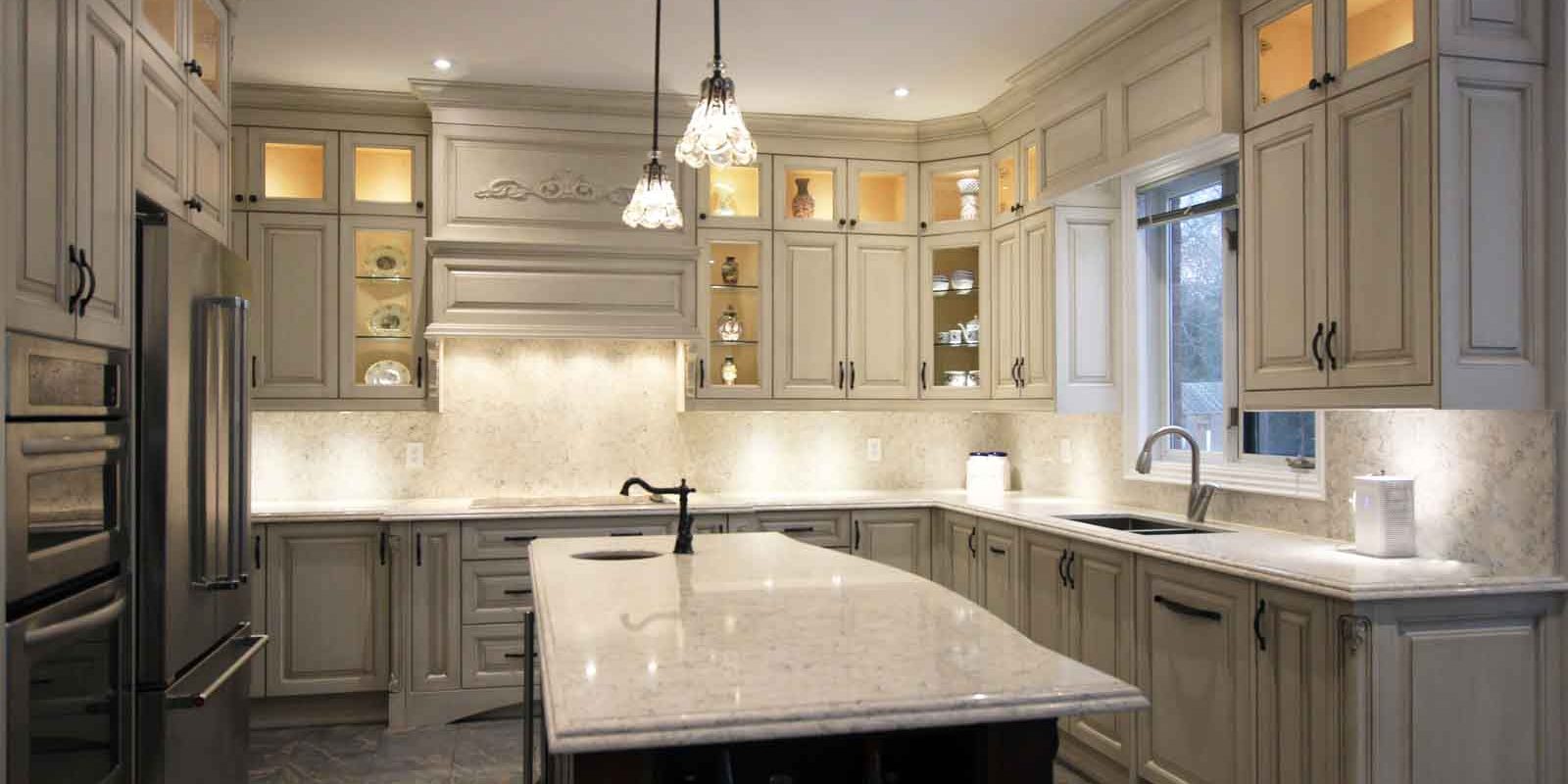 A spacious kitchen with light gray cabinets, a large island, and stainless steel appliances.