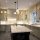 A spacious kitchen with light gray cabinets, a large island, and stainless steel appliances.