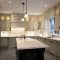 A spacious kitchen with light gray cabinets, a large island, and stainless steel appliances.
