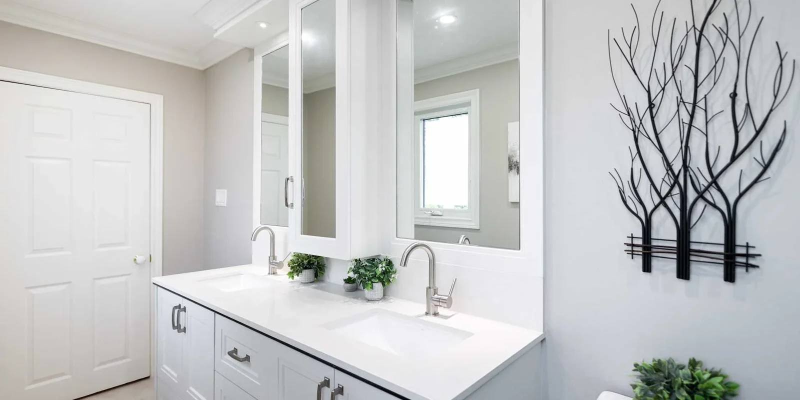 usersFfed afe da afffacdFlibraryFeefefe f b debffdFJA bathroom mana Modern white bathroom vanity with double sinks and a decorative tree wall art.